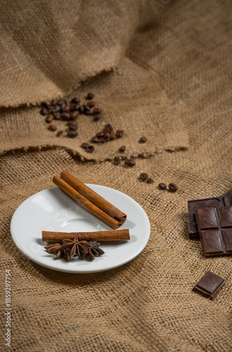 Cinnamon sticks, chocolate and coffee beans on a burlap background