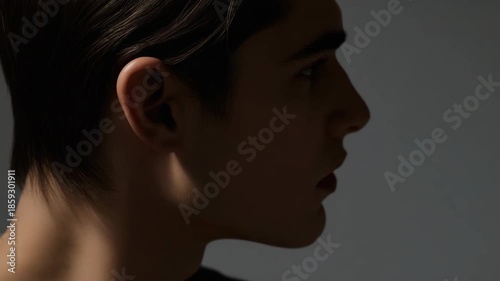 Young adult male profile portrait side view low light portrait with dramatic soft lighting