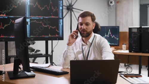 Focused at work, analyzing the data. Two male exchange workers are in the office together