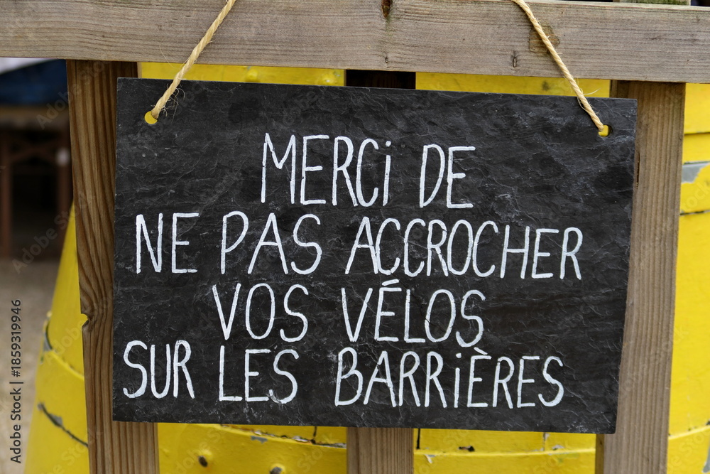 Obraz premium Merci de ne pas accrocher vos vélos sur les barrières. Inscription blanche sur grande ardoise noire.
