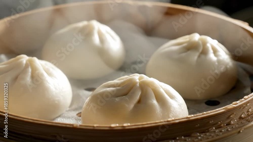 Ultra close-up of piping hot steamed baozi buns softly releasing visible steam inside a traditional bamboo steamer basket buns, cooking, food