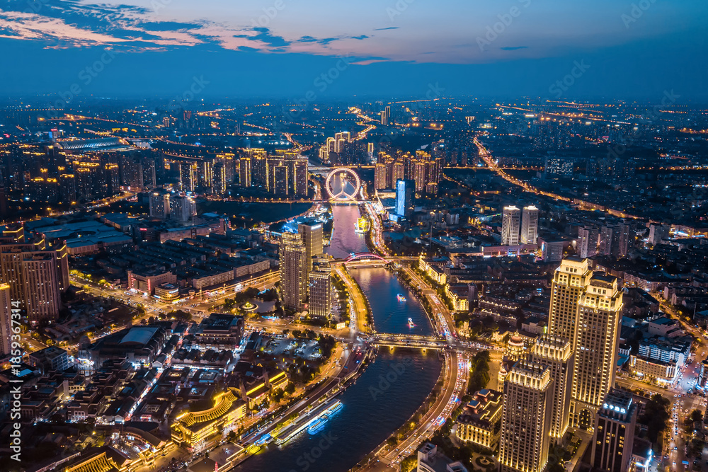 Obraz premium Aerial view of the Haihe River and Tianjin Eye Ferris wheel at night in Tianjin, China.