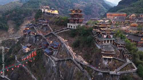 Aerial view of Wangxian Valley's cliffside buildings and walkways, presenting a contrast of traditional architecture against the rugged terrain, Wangxian Valley, China.