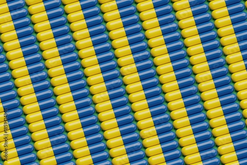 Yellow and blue pills on green surface. Top flat view