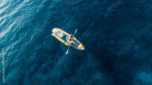 Fotografie Woman swims on kayak in summer blue sea. Drone view, top down