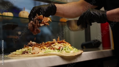A chef makes shawarma in a café.  He fries meat.  Close-ups. 