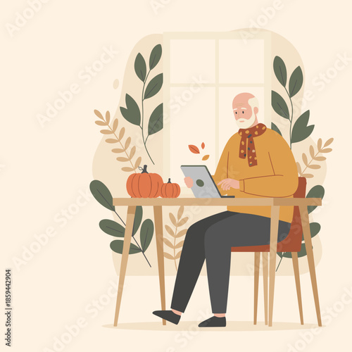 Happy senior man uses a tablet computer at home during autumn surrounded by pumpkins and fall foliage