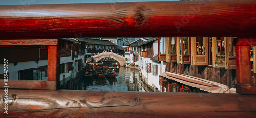 Photography Framed view of a canal bridge with traditional houses and scenic reflections