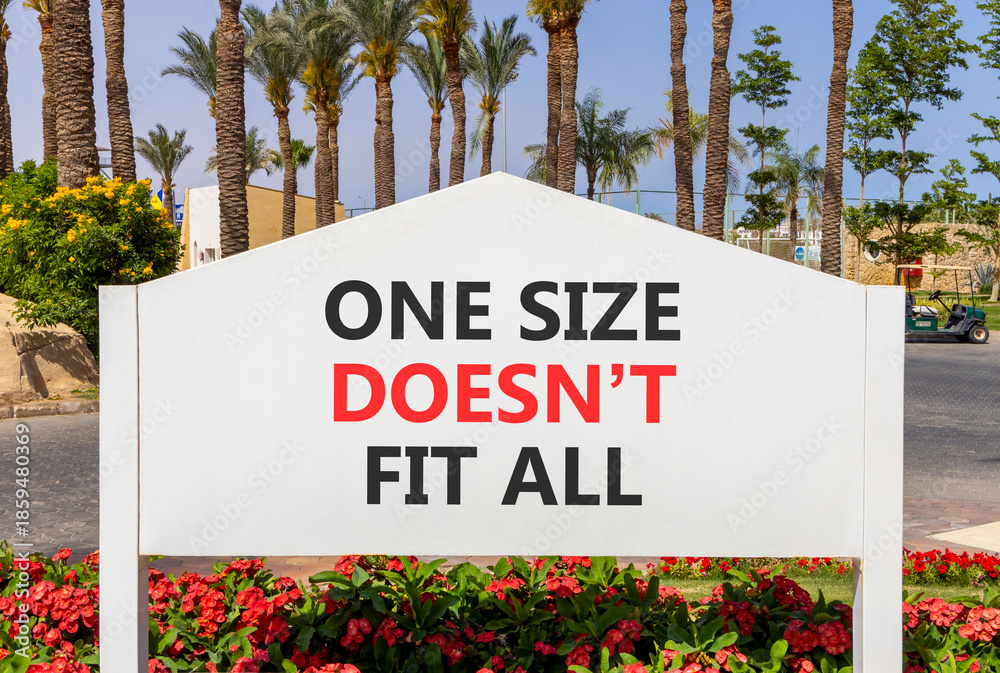Naklejka premium One size does not fit all symbol. Concept words One size does not fit all on beautiful white road sign. Beautiful palm trees blue sky background. Business one size does not fit all concept. Copy space
