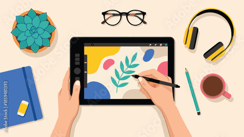 Creative workspace flat lay with hands drawing on a digital tablet