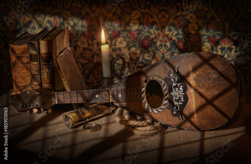 old broken, damaged mandolin with candle, candlelight, old leather books, rope, telescope, musical instrument