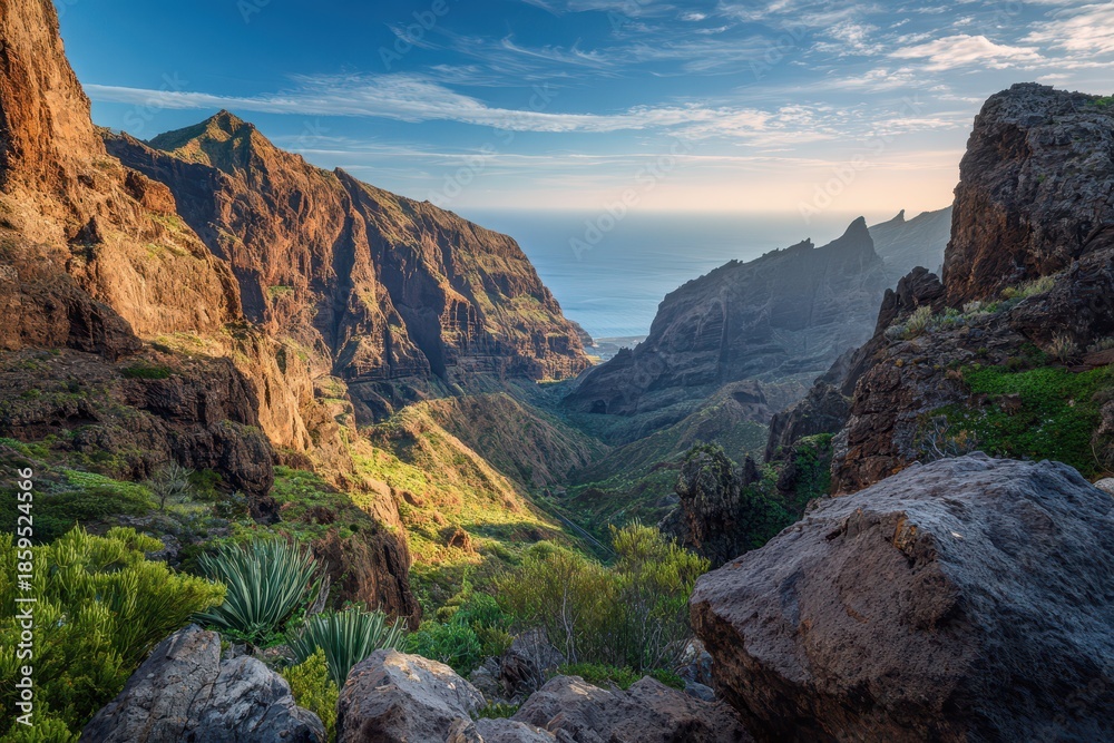 Fototapeta premium Sunlit Masca Canyon in Tenerife: limestone cliffs, winding river and lush gorge