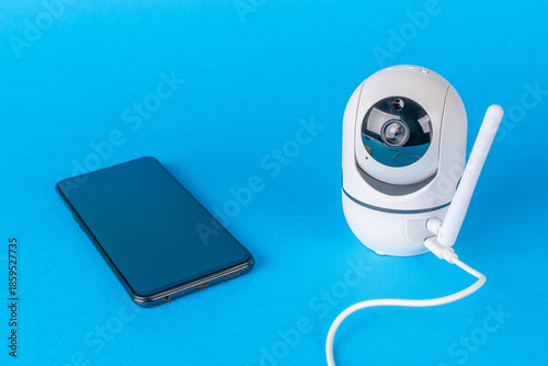 Wallpaper Mural Modern Home Security: Smartphone and Wireless Camera on Vibrant Blue Background Torontodigital.ca