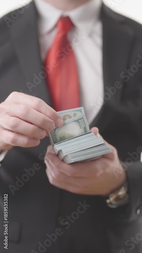 Headless businessman in suit counting a pack of money