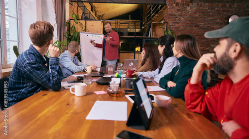 Tableau sur toile Business team listening to presentation in modern coworking space