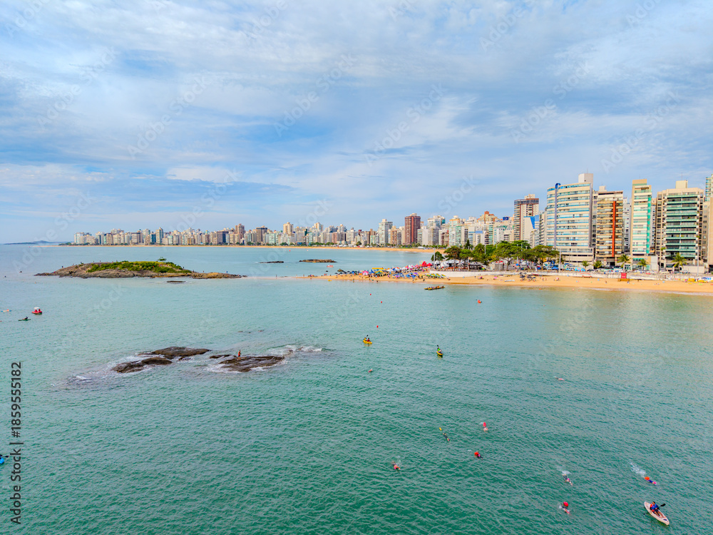 Fototapeta premium Imagem aérea da praia da costa em Vila Velha com o morro do Moreno ao fundo durante um evento esportivo de natação. Esporte aquático no litoral do Espírito Santo.