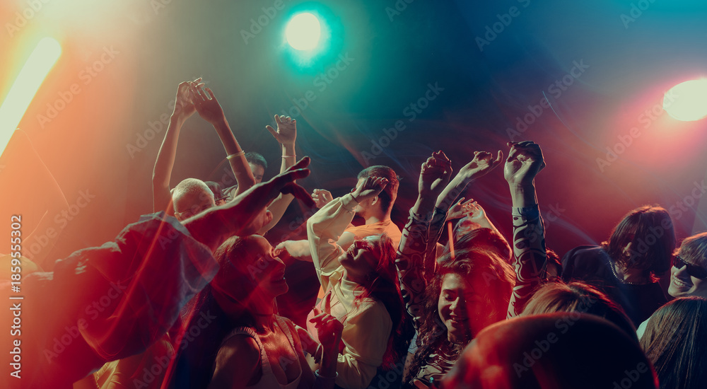 Obraz premium Expressive crowd movement during night music event. Concept of emotional intensity, shared experience, rhythmic freedom, immersive soundscape and Christmas party atmosphere.