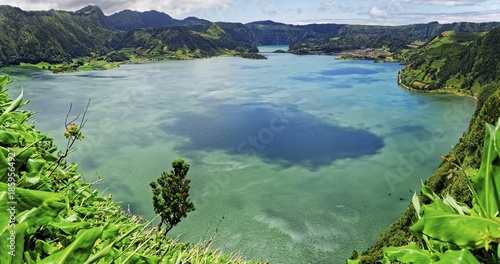 Calming view of the blue lake Lagoa Azul with the green hilly landscape under a clear sky, Lagoa Azul, circular hiking trail, Caldeira das Sete Cidades, Sete Cidades, Sao Miguel Island, Azores, Portugal