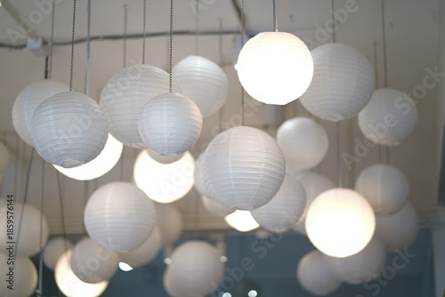Elegant White Paper Lanterns Hanging from Ceiling in Contemporary Interior Space, Soft Lighting Creating a Cozy and Inviting Atmosphere for Events