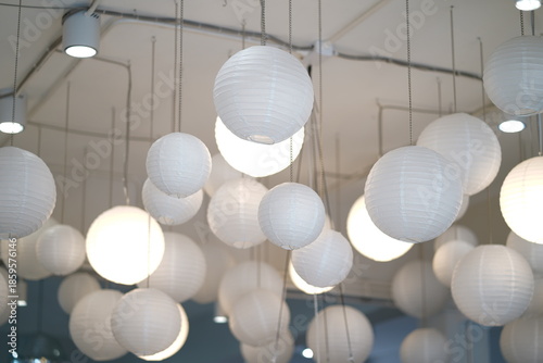 Elegant Collection of White Paper Lanterns Hanging from Ceiling in Modern Interior Space with Soft Lighting for Stylish Ambiance