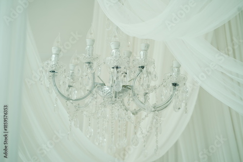 Elegant Crystal Chandelier with Sheer White Drapery Background in Soft Natural Lighting