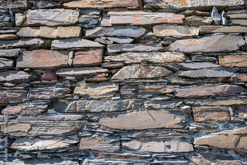 Photograph showcasing rugged limestone and granite wall with moss and shadow play for artistic projects