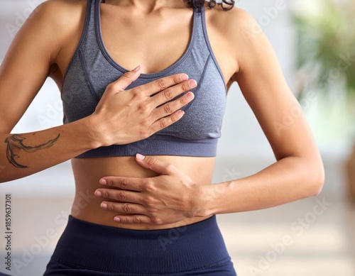 Woman practicing mindful breathing exercise with hands on chest and abdomen