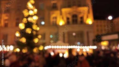 Out of focus night city environment with Christmas and new year's decorations and moving unrecognizable people, suitable for background.