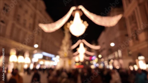 Out of focus night city environment with Christmas and new year's decorations and moving unrecognizable people, suitable for background.
