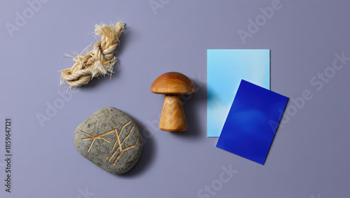 Artistic Still Life Composition Featuring a Rope, Stone, Mushroom, and Colored Cards on a Purple Surface, Evoking a Sense of Nature and Creativity