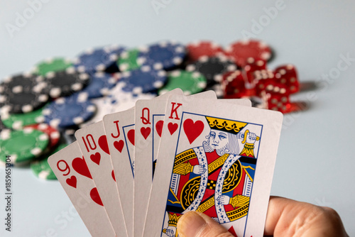 фотографія Hand holding hearts royal flush poker cards