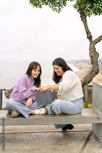 Friends sharing digital content relaxing by sea