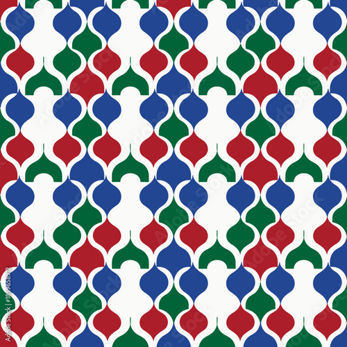 Seamless geometric pattern with repeating red, green, and blue ogee shapes on a white background, creating a vibrant and retro decorative design.