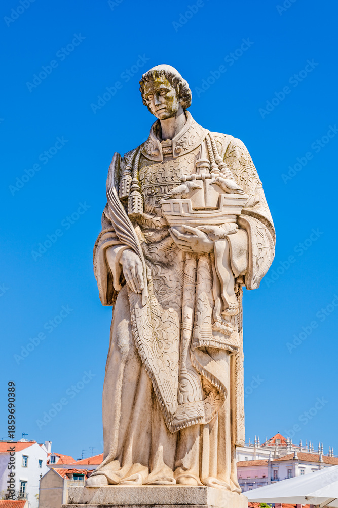 Fototapeta premium Statue of St Vincent of Saragossa or Sao Vicente de Fora, patron saint of the city, holding a boat with 2 ravens (symbols of Lisbon), at the lookout Miradouro Portas do Sol in Alfama, Lisbon, Portugal
