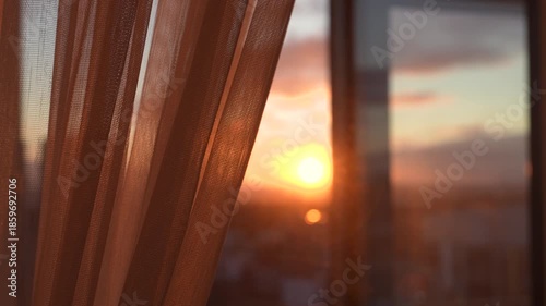 Golden hour sunset shining through sheer window curtain, with warm light filling room and creating serene and peaceful atmosphere. Pull back curtain from window at home for light at sunrise.