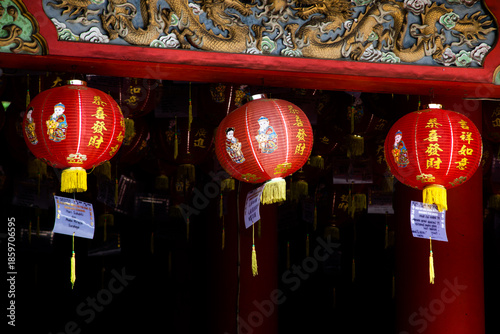 Red Chinese Lanterns Hanging Under Ornate Temple Roof With Dragon Relief