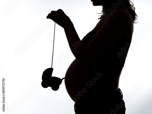 Elegant silhouette of a pregnant woman on a white background, symbolizing motherhood, ожидание, нежность и новую жизнь. High quality photo