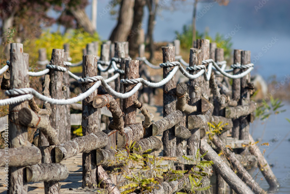 Naklejka premium Rustic Wooden Fence by Lakeside Path