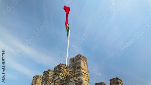 Portuguese flag waving on a castle tower.