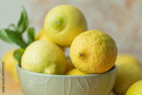 Foto Fresh whole lemon in ceramic bowl with leaf detail, soft natural light and blurred background