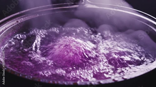Close up of boiling liquid in a cooking pot with steam culinary preparation visual
