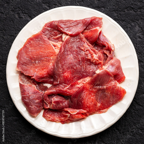 Raw Beef Meat Slices on White Plate, Top View
