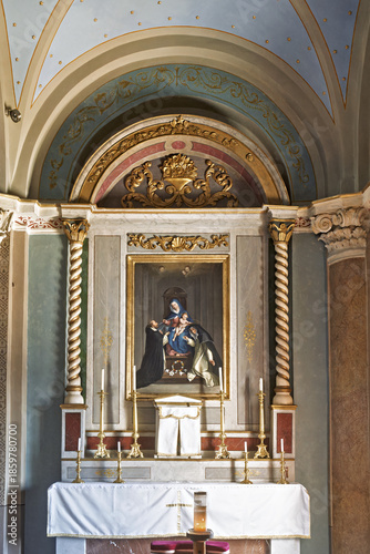  the Cathedral of Saint George in Ano Syros showcasing  columns, arches, and a vaulted ceiling with intricate artwork. The central altar is draped in white cloth and framed by golden columns 