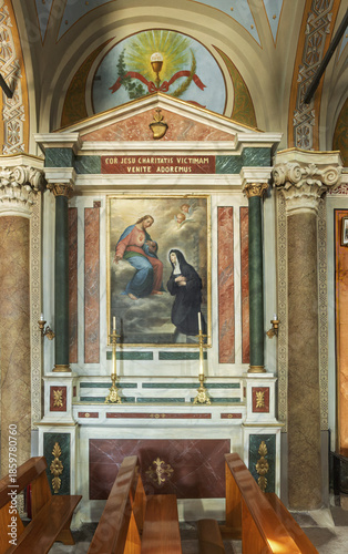  the Cathedral of Saint George in Ano Syros showcasing  columns, arches, and a vaulted ceiling with intricate artwork. The central altar is draped in white cloth and framed by golden columns 