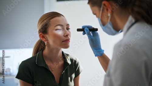 Neurologist testing woman eyes reflexes during checkup. Doctor checking health