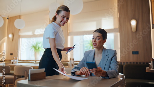 Smiling guest talking waiter advising about lunch dish in restaurant closeup