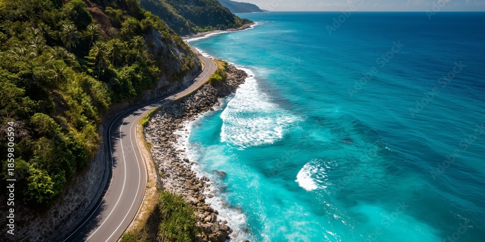 Obraz premium Scenic coastal road winding along a rocky shore with turquoise water.