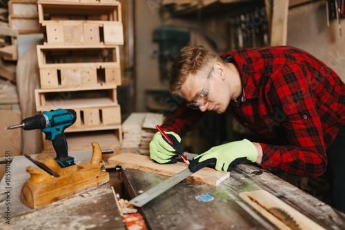 Fotografía Young stylish carpenter wearing a shirt working in his workshop, focusing on a w