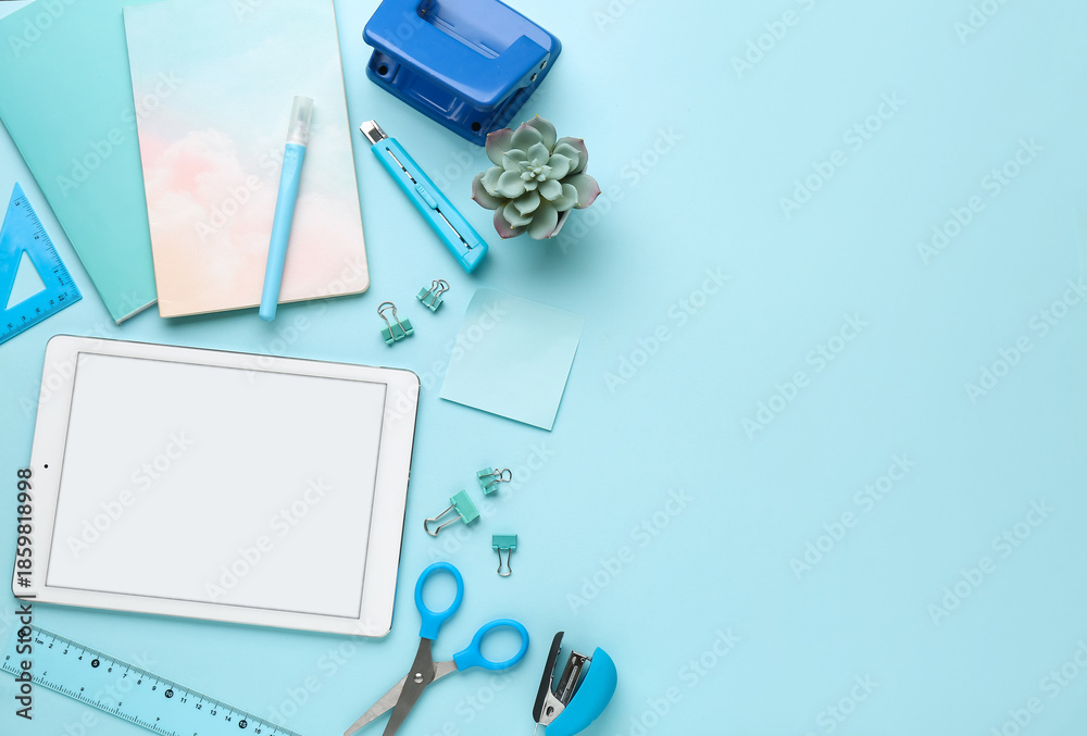 Fototapeta premium Set of school stationery with tablet computer and houseplant on blue background