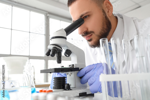 Male scientist looking thro...